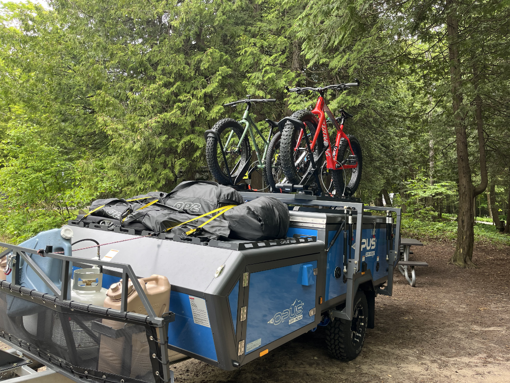 The Opus OP2 Camper with two Fat Bikes and a mountain bike on the roof rack.