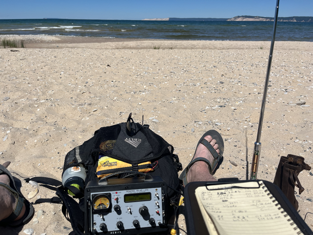 The TR-45L resting on a backpack. The AX1 antenna is on the right along with a log book in the foreground. There is a big white dude's foot with sandal in the frame as well - regrettably.