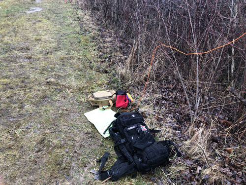 Gear on the ground on a muddy trail.
