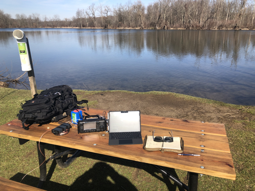 Station setup on picnic table by pond.