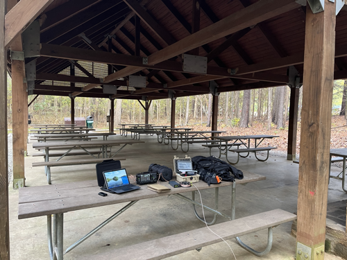 Picnic table with Surface Go 2, IC-705, Pelican Gear Box, and backpack.