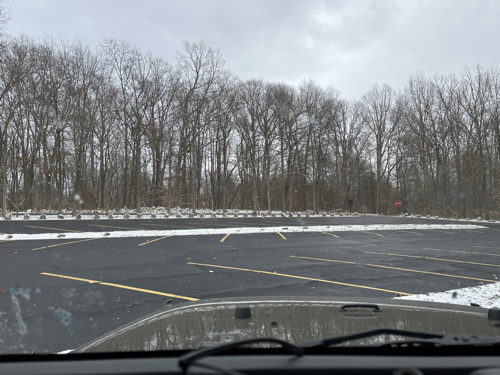 A very empty parking lot as seen from the inside of the Jeep.
