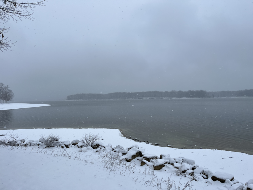 Reservoir with snowy banks and heavy snowfall.