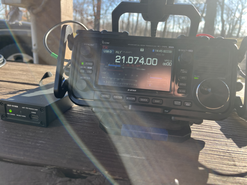 IC-705 and tuner on a picnic table in the sun at FYAO 2023.