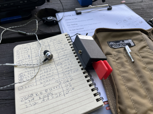 Logbook with earbuds and CW paddle.