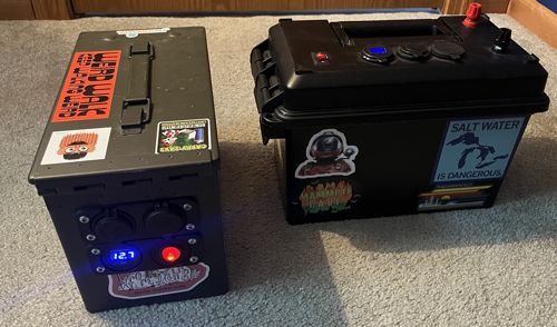Two battery boxes. One made from an ammo can and the other a plastic box manufactured by Powerwerx. Both are covered in stickers because it is well know that stickers improve performance.