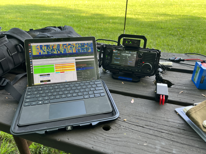Computer, radio, and CW paddle on a picnic table.