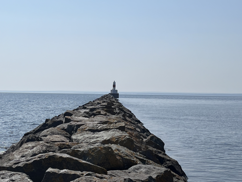A lighthouse at the end of a breakwall on Lake Superior.