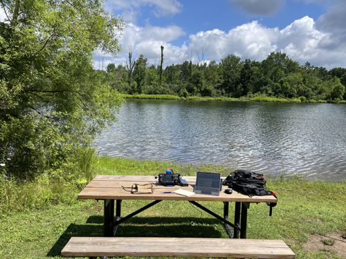 Radio gear on a picnic table near the pond.