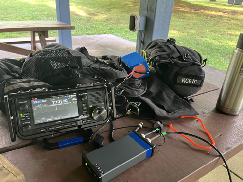 The IC-705, tuner, and assorted gear spread on a picnic table in a shelter at Wingfoot Lake State Park.