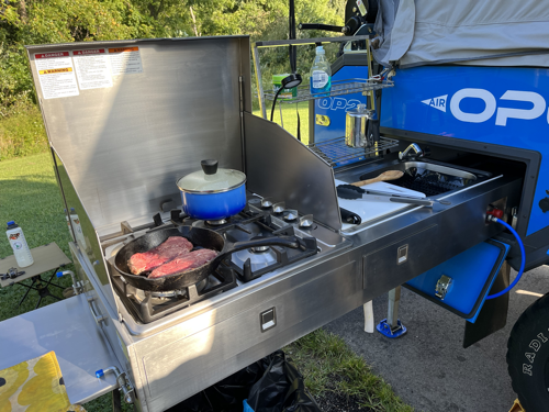 Dinner cooking on the pull-out kitchen of the Opus OP2 camper.