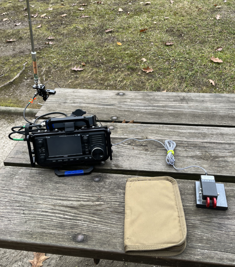 AX1, IC-705, log book, and paddles on a picnic table in far less hospitable weather than the day before.