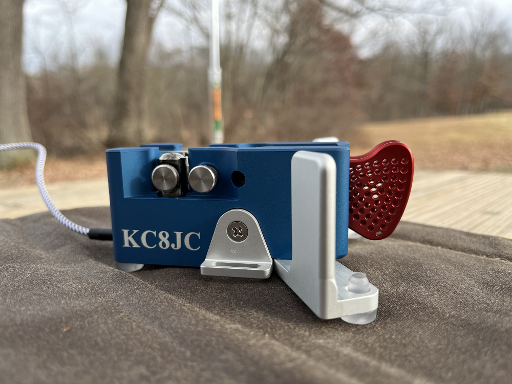 A blue Begali Traveler with red paddles and inscribed with KC8JC.