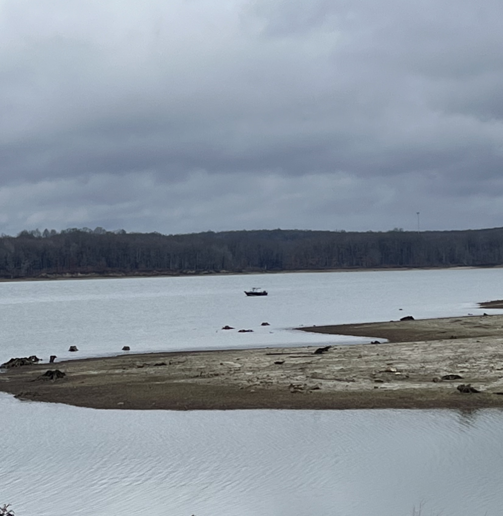 A small fishing boat on the reservoir. The picture is taken from quite a distance away.