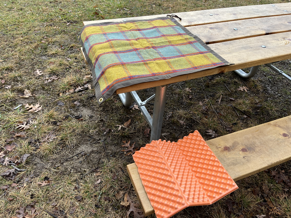 My plaid tarp on the picnic table and my foam pad on the seat.