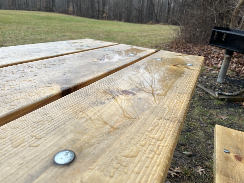 Water pooling on a new picnic table.