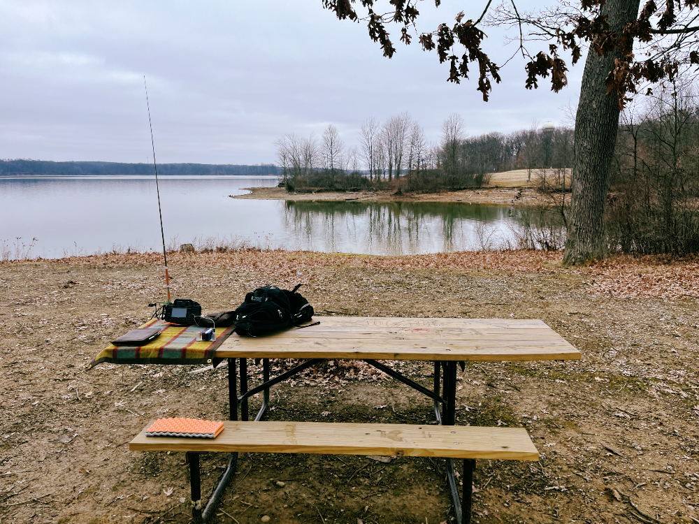 My CW station deployed on a tarp resting on a picnic table. It takes up less than a third of the total surface area of the table. The AX1 is barely visible.