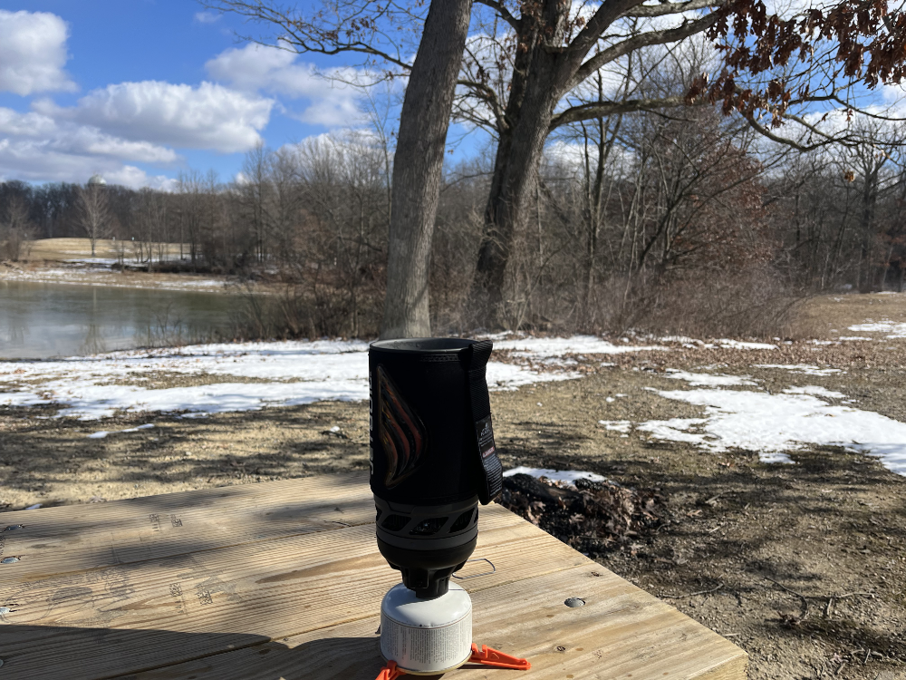 Jetboil on a picnic table boiling water for coffee. 