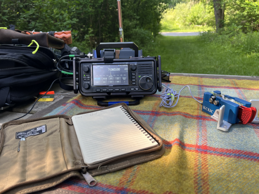 IC-705, logbook, and paddles on a tarp.