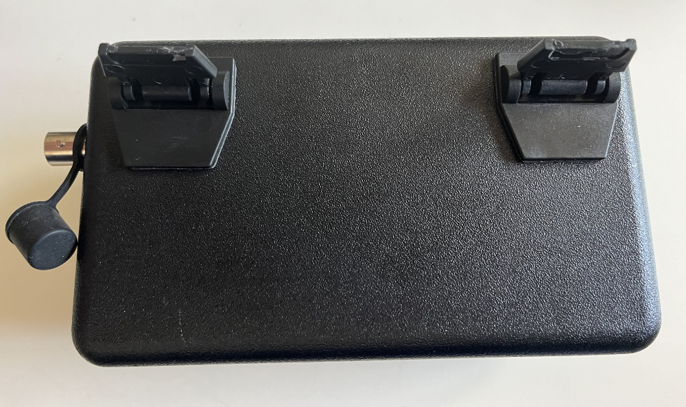 The TR-35 laying on its face with attached laptop feet showing. There is also a cover attached to the antenna output.