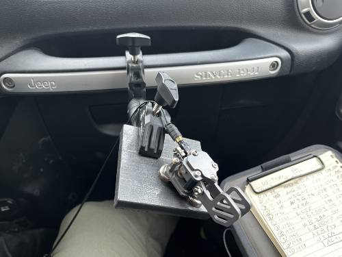 A slab of heavy metal held in place by a crab clamp. The clamp holds onto the grab bar in front of the passenger seat. Putikeeg paddles are clinging to the metal slab. A nifty clipboard can be seen resting on the leg of the photographer.